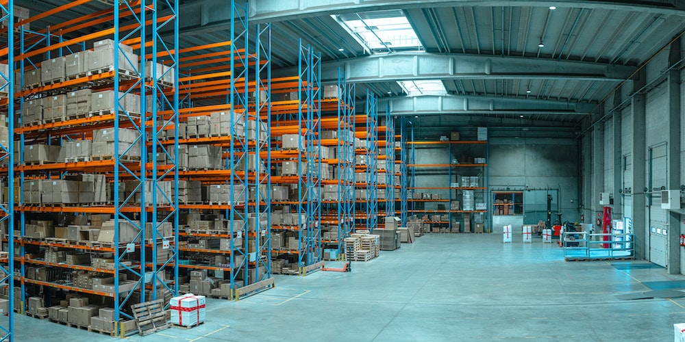 Distribution warehouse in the day with skylights and full inventory racks.